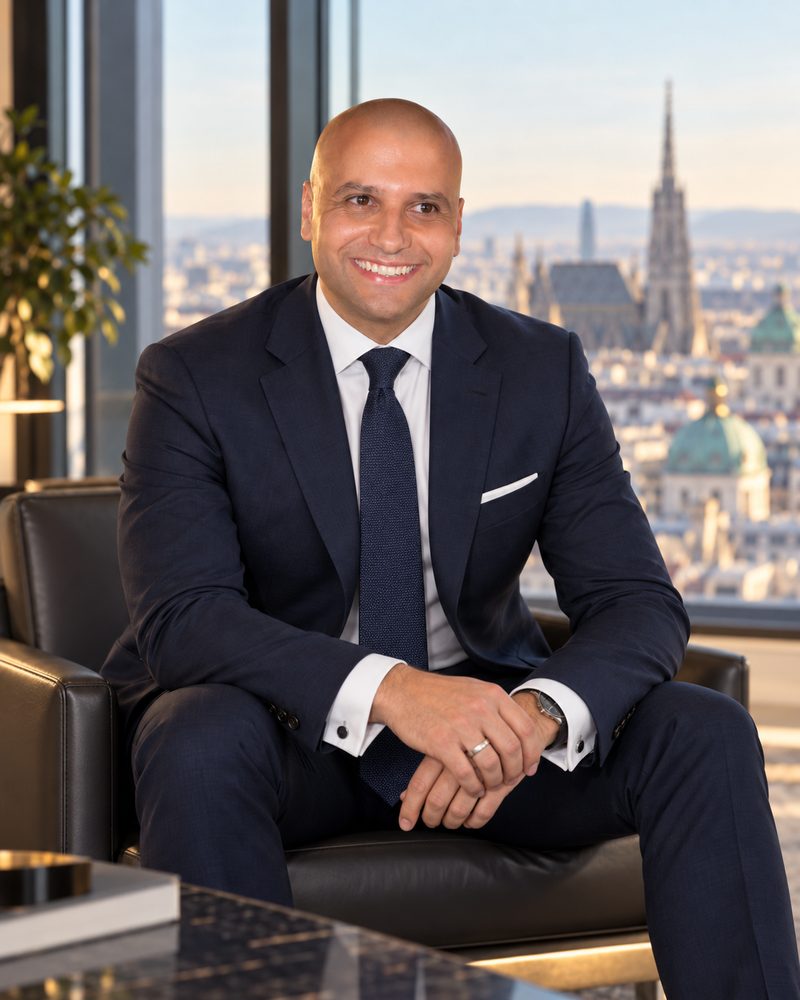 Essam El-Dakak sitting in a leather armchair in front of a window overlooking Vienna